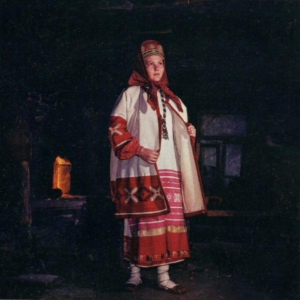 Женщина народном костюме, в лаптях и онучах.